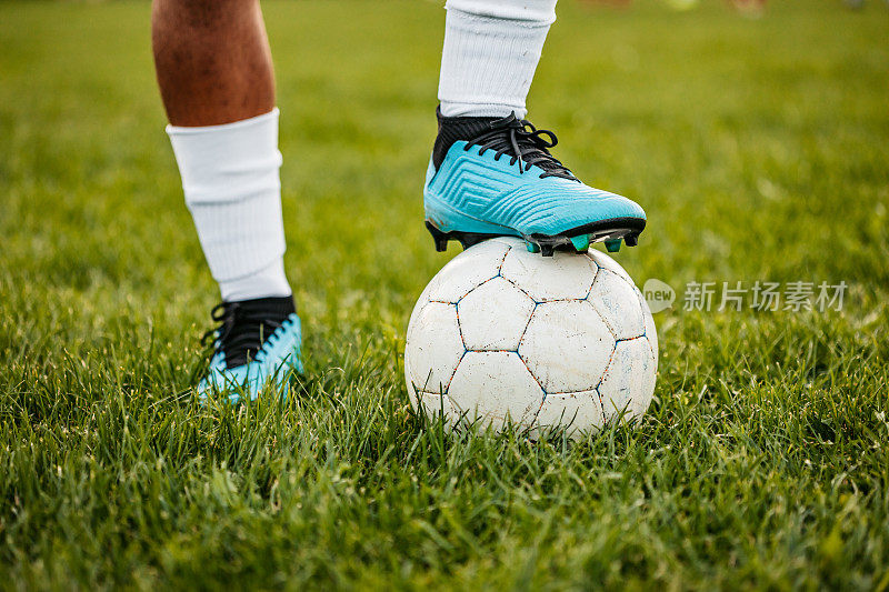 足球运动员的脚和球站在一起