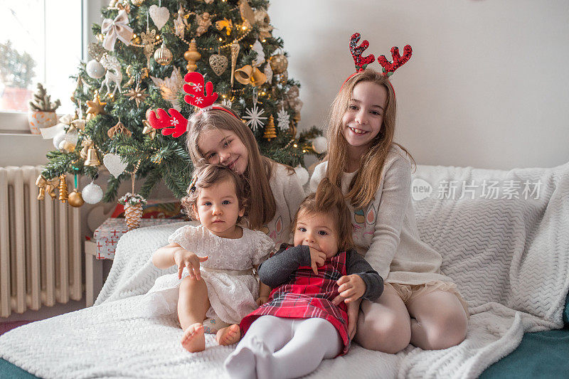 四个女孩坐在圣诞树下的公寓