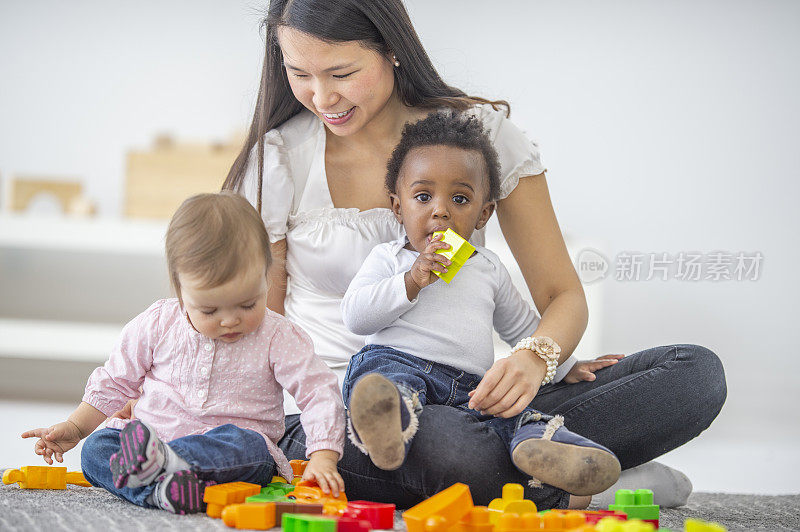 亚洲女幼儿园教师与她的学生玩