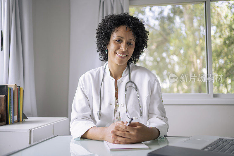 黑人女医生使用笔记本电脑进行远程医疗视频通话的肖像。