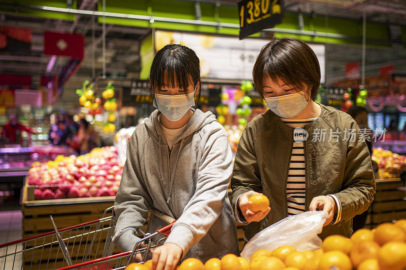 母女俩在超市买水果。