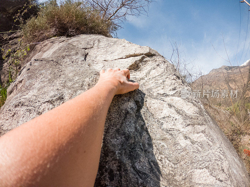 女登山者把手伸向岩石