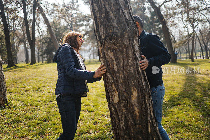 年轻的情侣在公园里玩耍，在美丽的自然中享受时光
