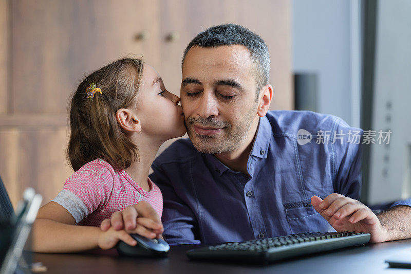 父亲和女儿一起在家里使用电脑