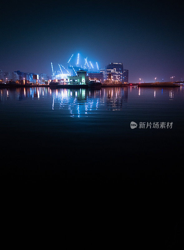 迪拜河，灯火通明的建筑和起重机