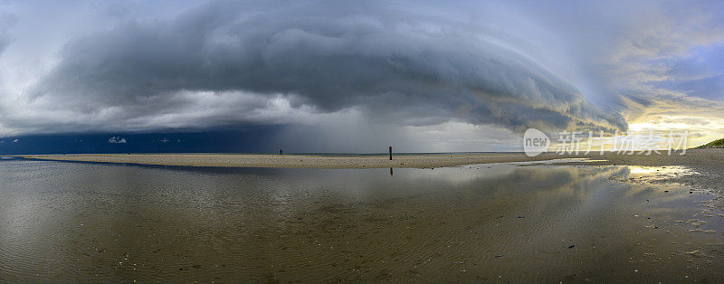 日出时，特塞尔岛海滩上的风暴云接近瓦登海