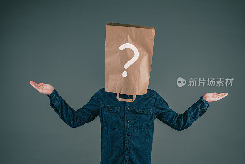 一个年轻人头上戴着一个纸袋，袋子上有一个问号，问为什么，寻找答案，黑色的背景