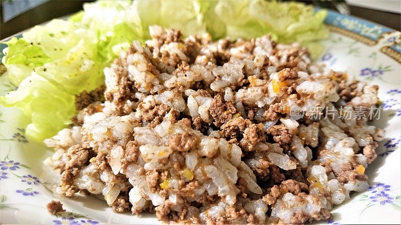 阳光在肉酱、米饭和生菜上发挥作用。