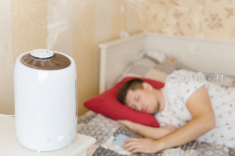 白色加湿器散发蒸汽。将卧室内的干燥空气加湿。选择性地关注蒸汽。