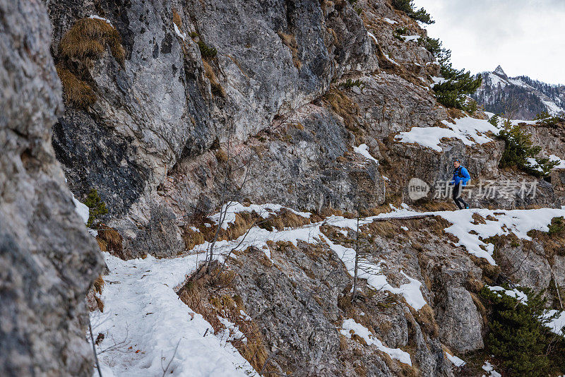 一个白种人在雪山上跑步