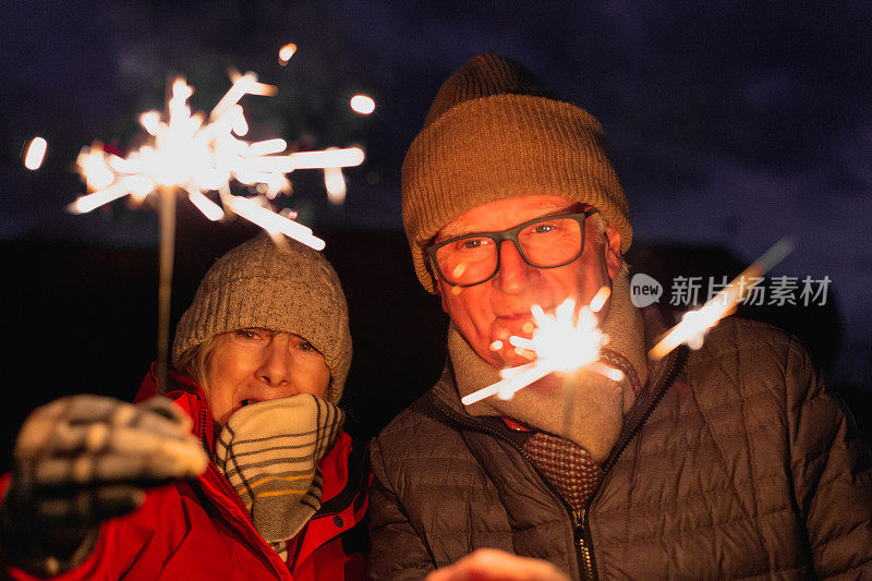 快乐的老夫妻在户外拿着烟花