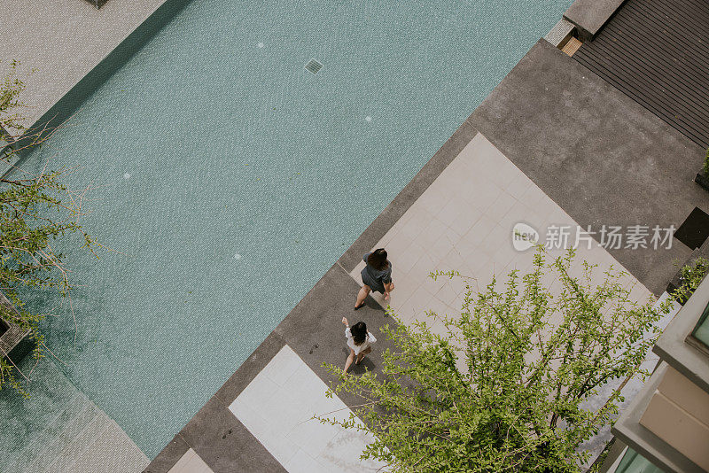 两个年轻的女人在游泳池边玩和放松。