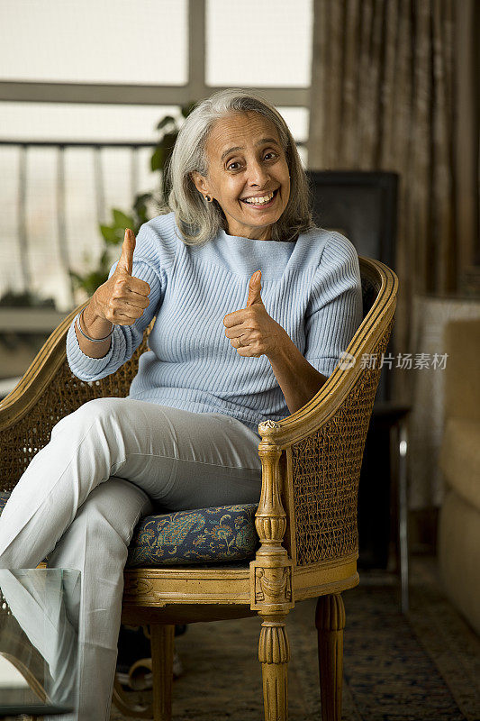 快乐的老妇人在家里竖起大拇指