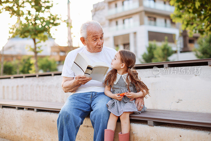 爷爷在大自然中给小孙女讲故事。