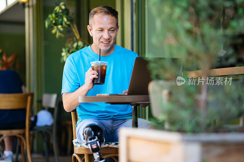 一个年轻人在咖啡店里用笔记本电脑。