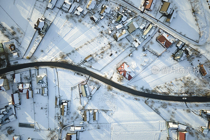 在寒冷的冬天，乡村郊区城镇地区，屋顶被雪覆盖的私人住宅的鸟瞰图