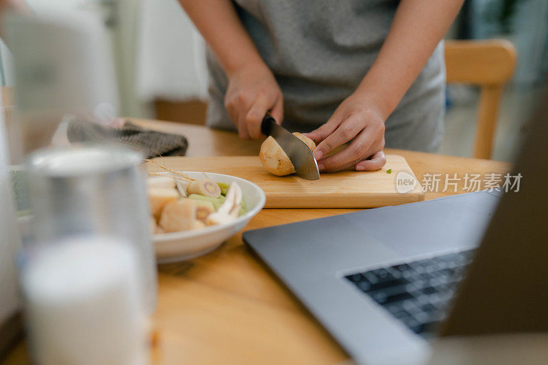 情侣们利用空闲时间一起学习烹饪技巧。