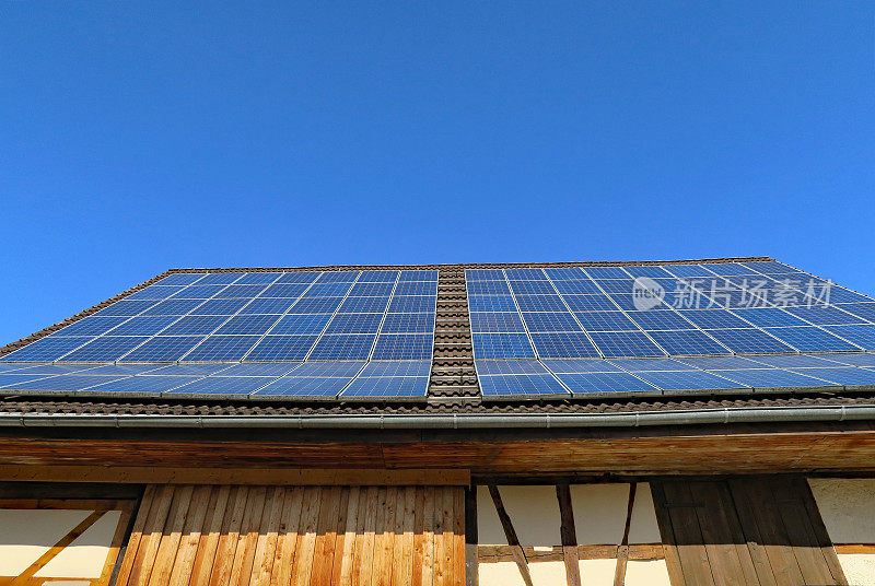 屋顶上有太阳能电池的旧框架房子