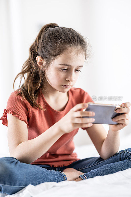 青春期前的女孩沉迷于上网，沉迷于社交网络，总是把手机拿在手里。