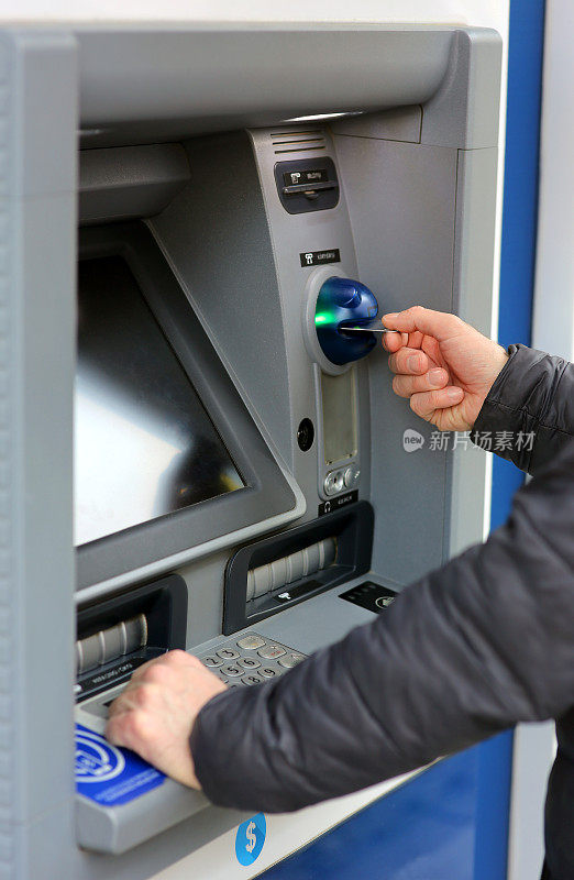 一名男子在自动取款机上用信用卡进行交易