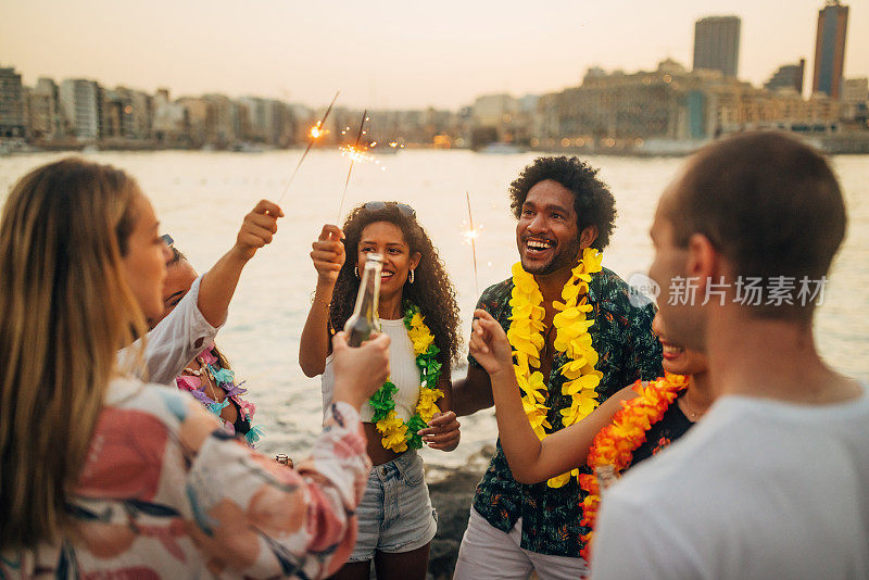 一群不同的朋友在海滩聚会上玩得很开心，一起出去玩，喝啤酒