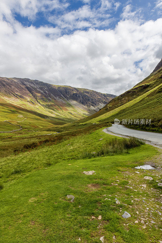 风景优美的山口公路蜿蜒穿过英格兰坎布里亚湖区的一个山谷。