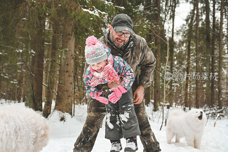 爸爸和女儿走在冬天的森林里