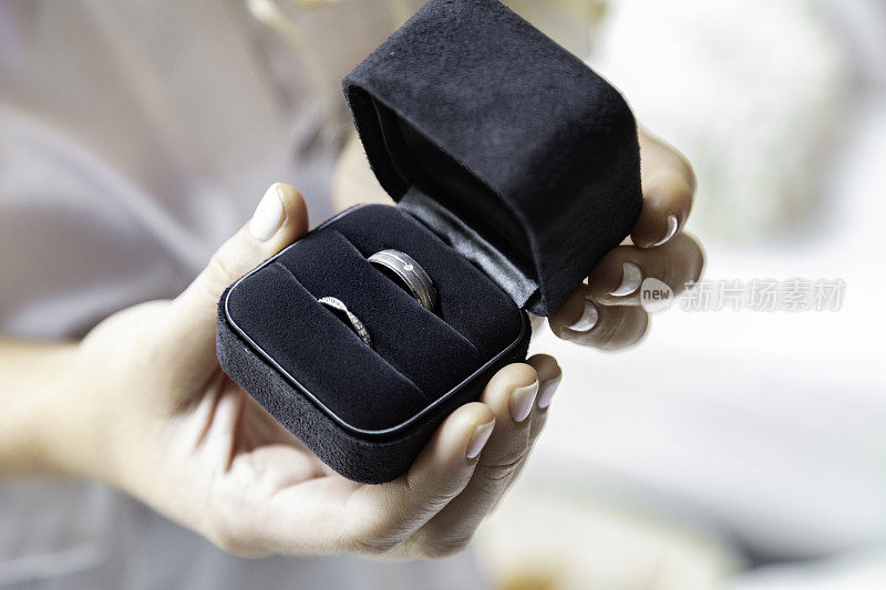 新娘手持结婚戒指首饰盒。