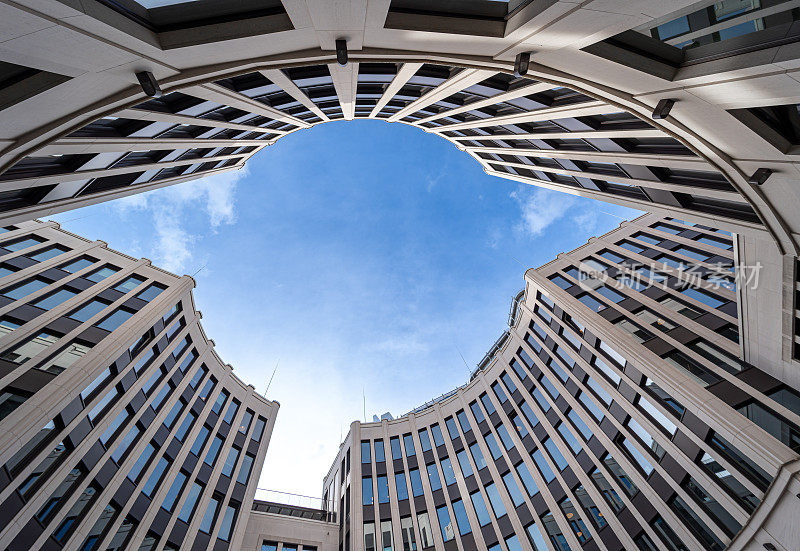 多云天空下现代办公楼的低角度视图