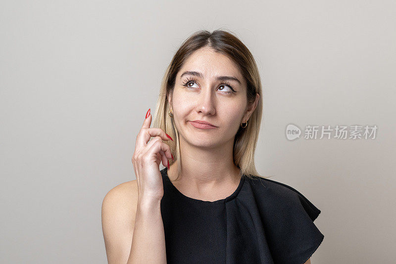 中年成年女性在明亮的灰色背景上思考的肖像