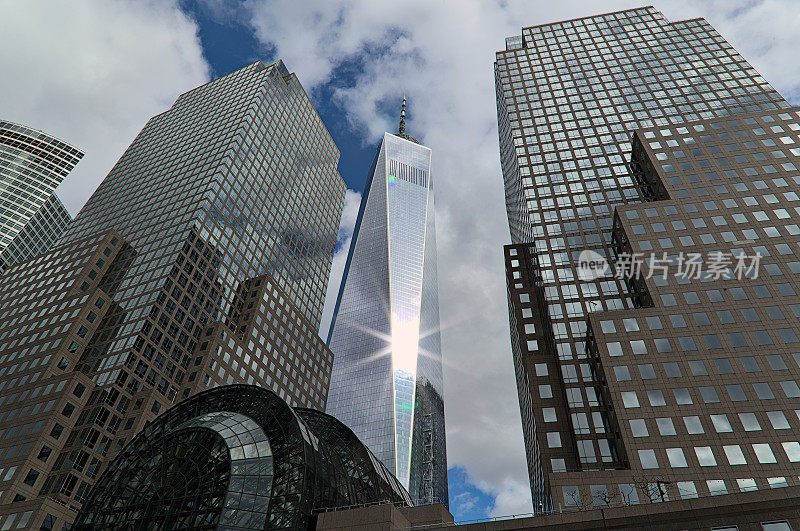 曼哈顿市中心的天际线视图(太阳耀光从一座摩天大楼照耀)贸易中心(世界中心)玻璃高层塔纽约市市中心旅游目的地办公大楼的细节仰望天空