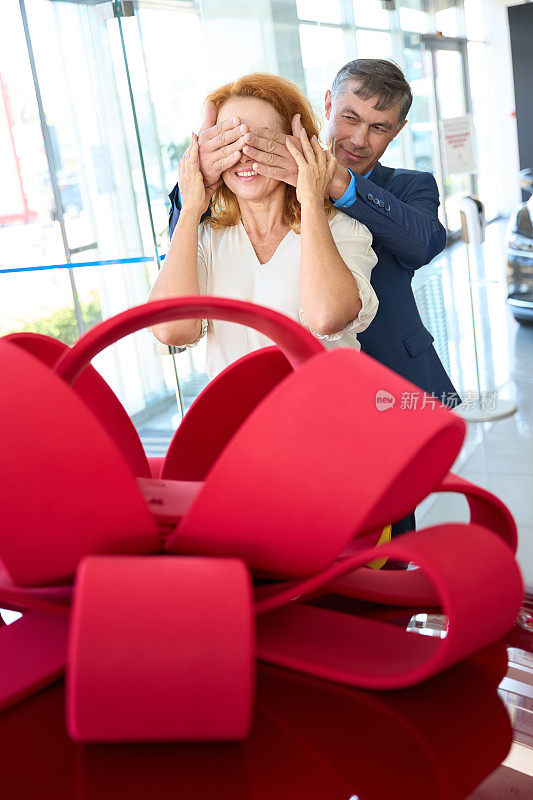 男人合上女人的眼睛他的手掌，他给她红色的车