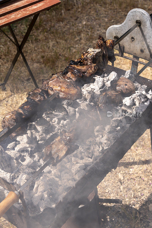 烤串的羊肉，白色的烟从覆盖着灰烬的木炭中升起