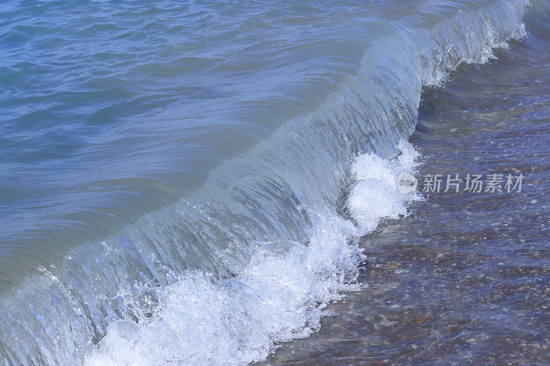 强大的海洋蓝色的海浪白色的泡沫。美丽的蓝色水背景。海浪汩汩作响。大海中的巨浪。不安分的水。动荡的大海。波涛汹涌的大海，波涛汹涌