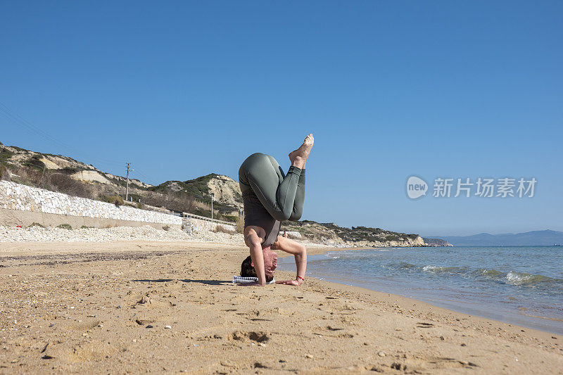 一名女子在海滩上练习瑜伽