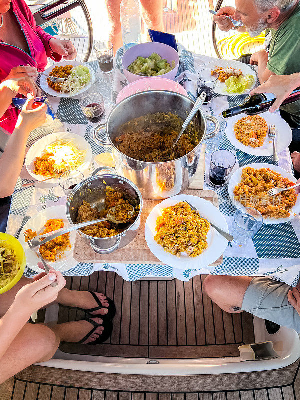 日落时分，船员们在停泊的帆船上吃晚饭