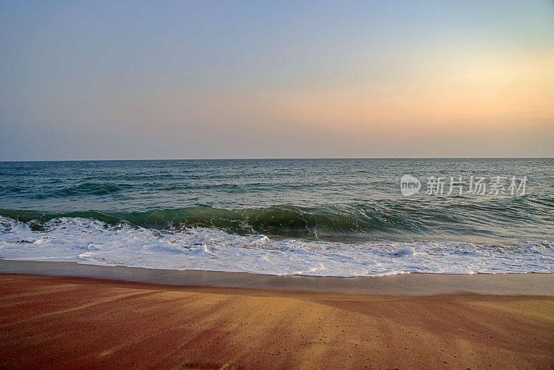 印度汉班托塔宁静的海滩，日落时波涛汹涌