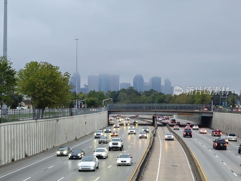高速公路上的交通和休斯顿市中心的天际线被云包围