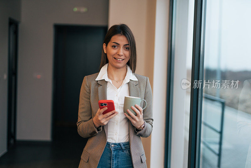 年轻的女商人使用手机和短信