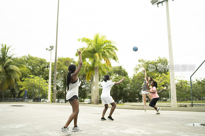 一群当地的朋友在附近的球场打篮球