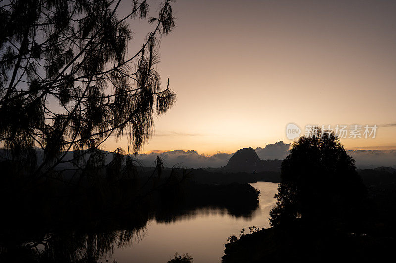 美丽的日落在瓜塔佩哥伦比亚安蒂奥基亚附近的麦德林peñol石头清澈的天空橙色的光和湖