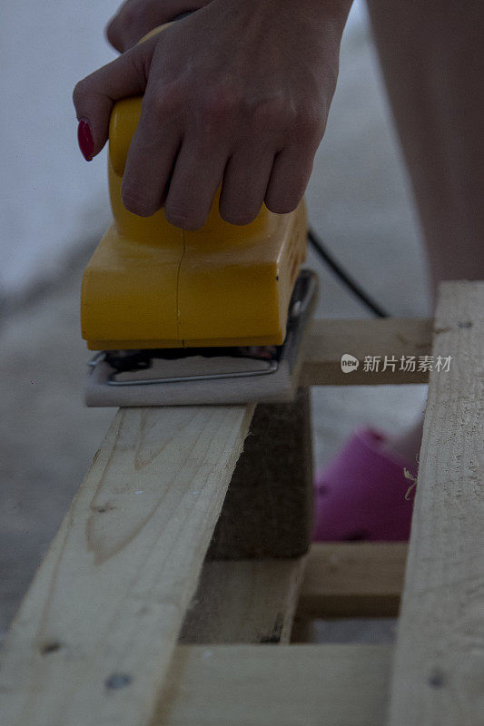 女木匠使用电动砂光机