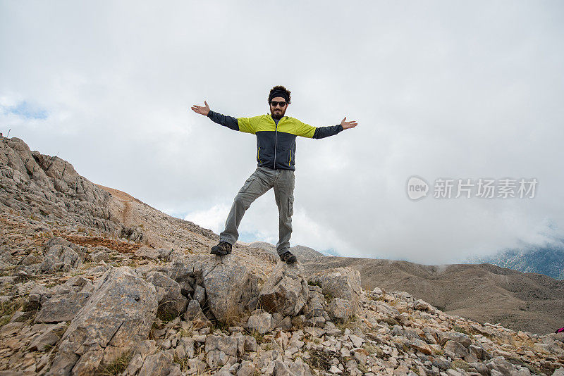 人高举双臂站在山上