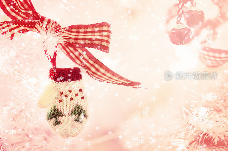 挂在白色圣诞树上的小手套装饰品