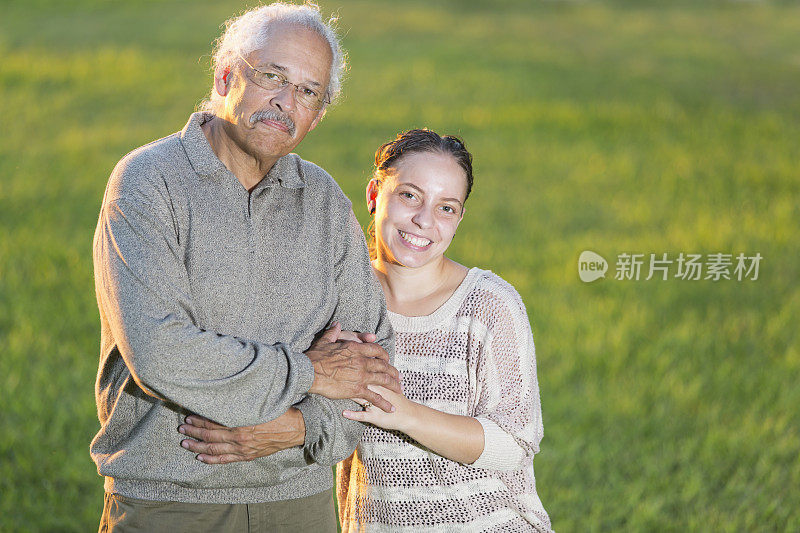 西班牙裔父亲和成年女儿一起站在户外