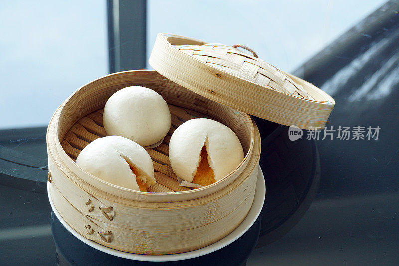 中国馒头或中国蛋黄蛋糊包在竹盘-传统的中国点心，选择焦点。