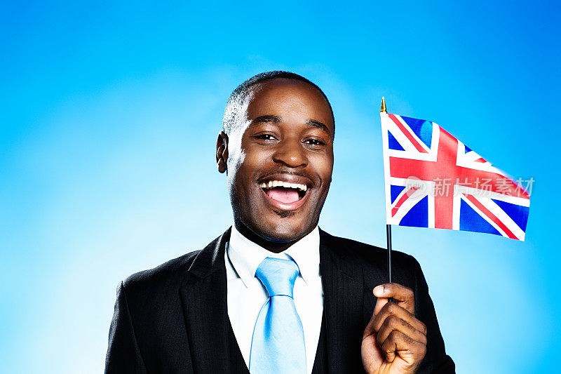 爱国的英国公民微笑着，挥舞着英国国旗
