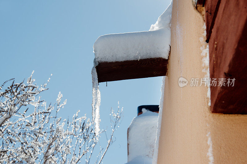 天沟上挂着冰柱，屋顶上有雪