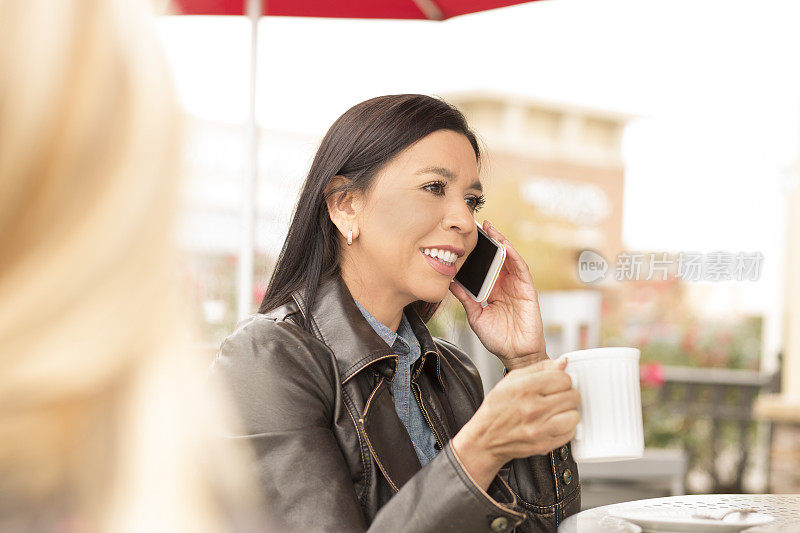 一个女人在户外咖啡馆用手机。