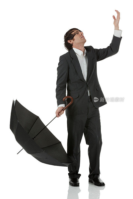 一个拿着伞向上看的商人